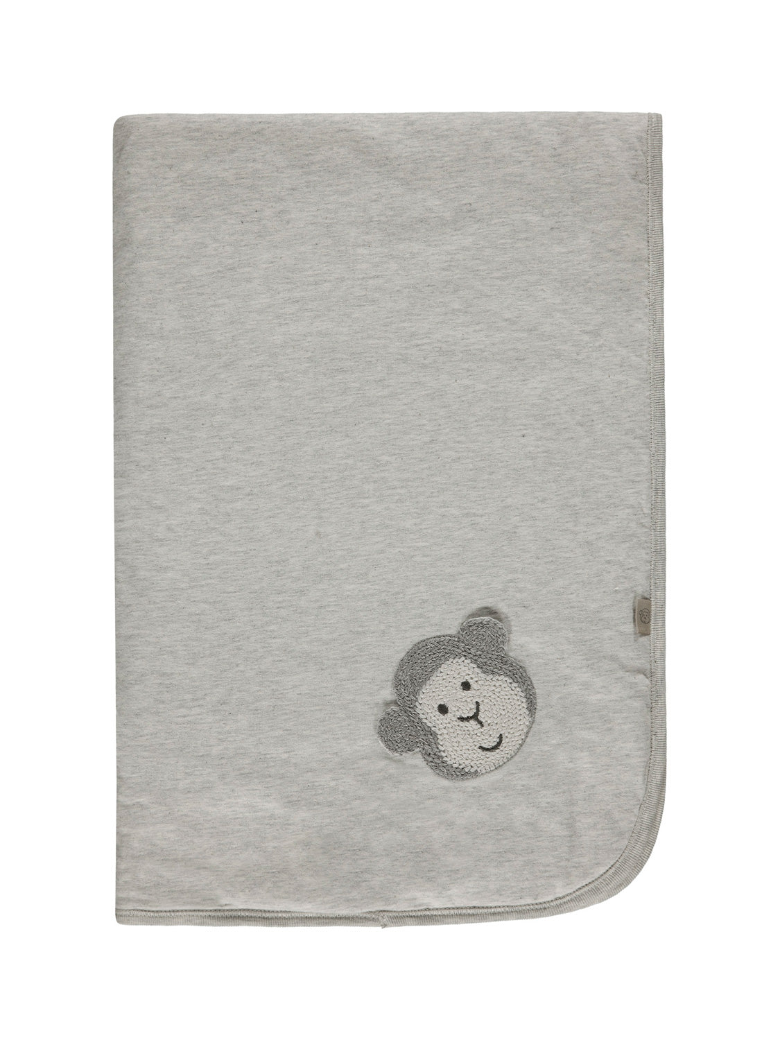 Decke Grau: Weiche Babydecke mit gestricktem Affengesicht-Applikation in einer Ecke, ideal für Komfort und Stil in der Baby- und Kindermode von bellybutton.
