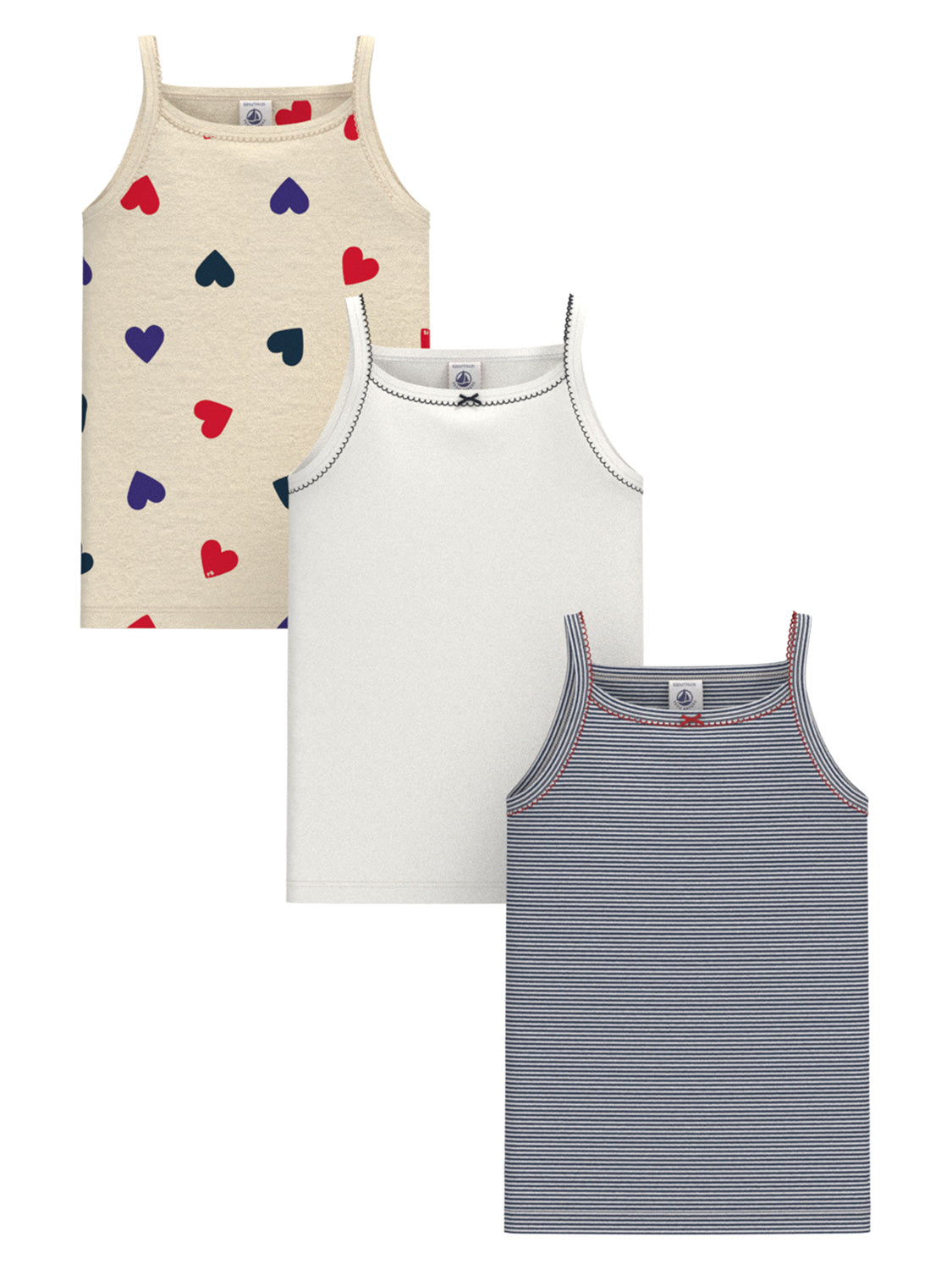 Unterhemd CŒUR 3er-Set: Mädchen-Camisoles mit Spaghettiträgern, herzbedrucktes Creme, schlichtes Weiß mit Schleife, navy mit feinen Streifen und roten Nähten.